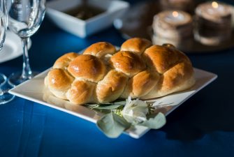 Neatly woven loaf of bread on blue tablecloth