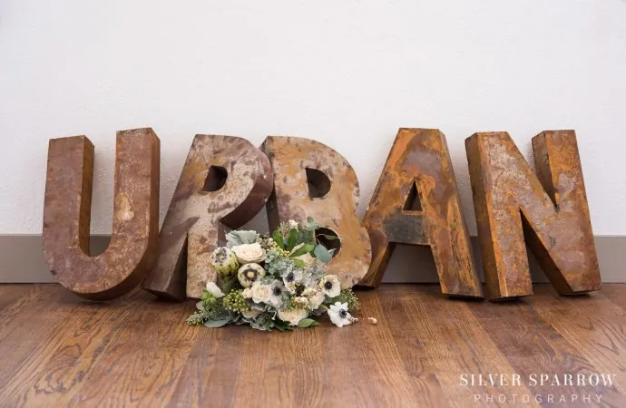 Flower bouquet in front of large, vintage letters that spell 