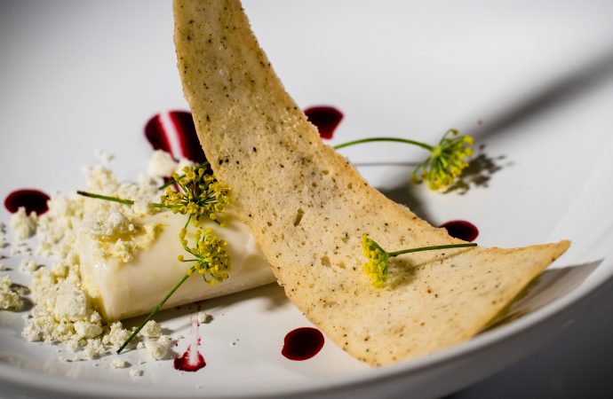 Plated food with fresh flowers and crumbled cheese
