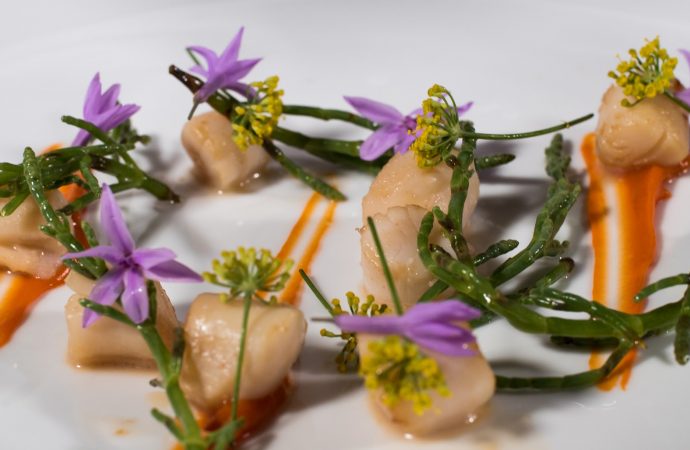 Finely plated meal with fresh flowers