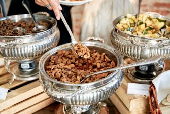 Mixed vegetables and bowl of meat on display at a buffet