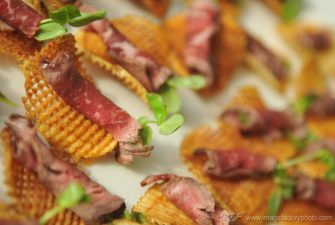 Plate of rolled roast beef on top of crispy waffle potato crisps