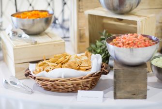 Buffet display with sliced baguette crisps and bowl of tomatoes