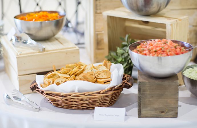 Buffet display with sliced baguette crisps and bowl of tomatoes