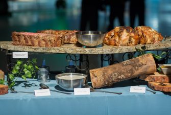 Various slabs of meat on a granite display setting on a buffet