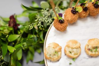 Plate of individual appetizers on display over a leafy green decoration