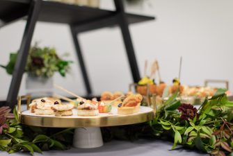 Various trays of appetizers on a decorated stand