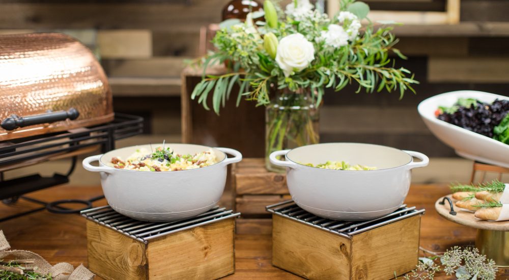 Serving dishes full of food on a decorated event table