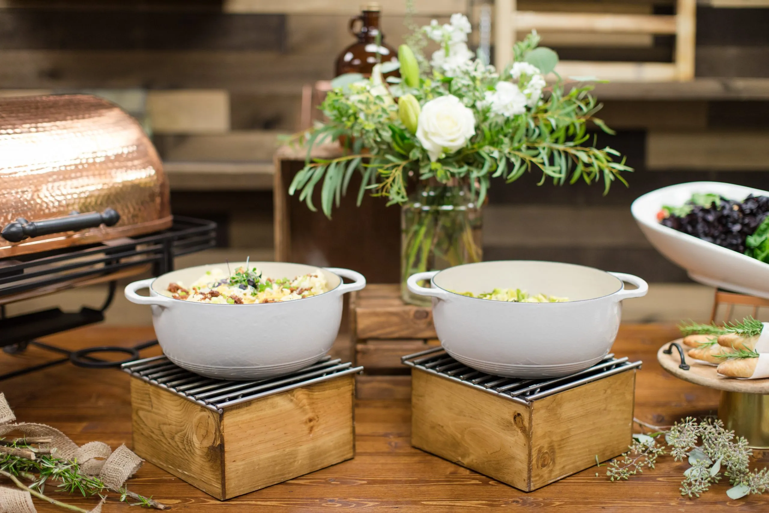 Serving dishes full of food on a decorated event table