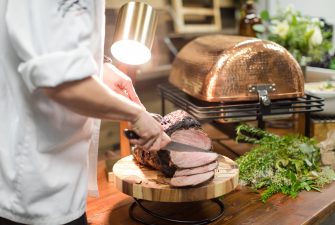 server cutting meat on a board at an event