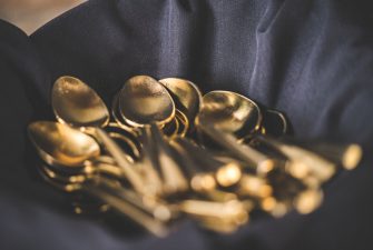 Basket of shiny spoons over a blue cloth