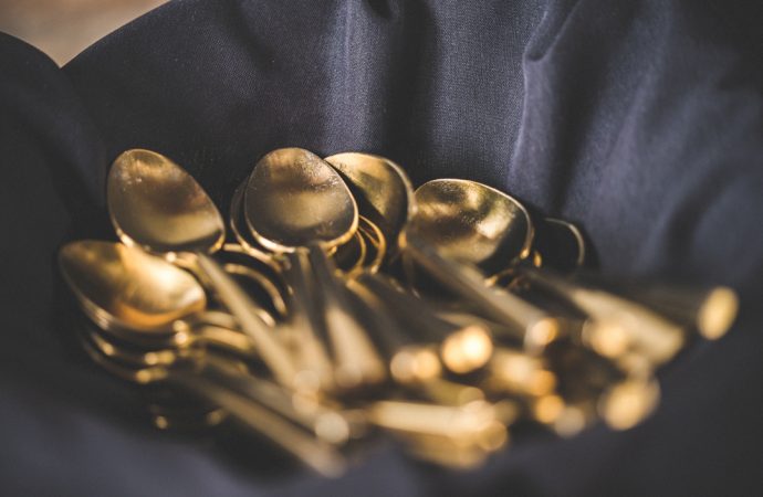 Basket of shiny spoons over a blue cloth