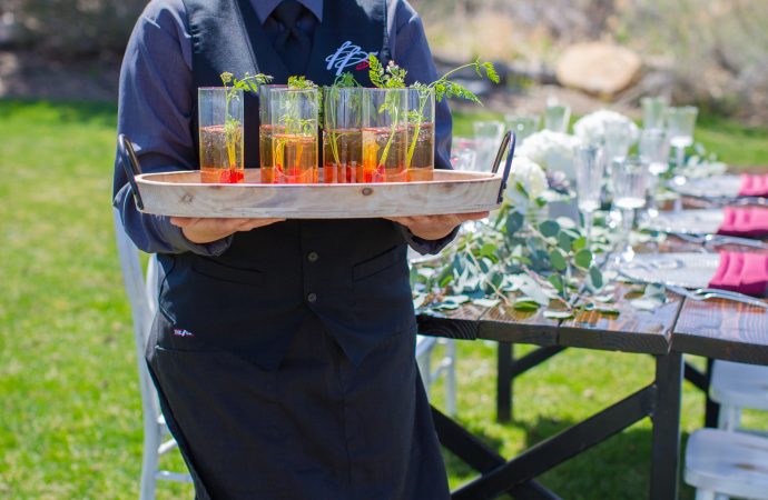 server holding tray of passed drinks at event