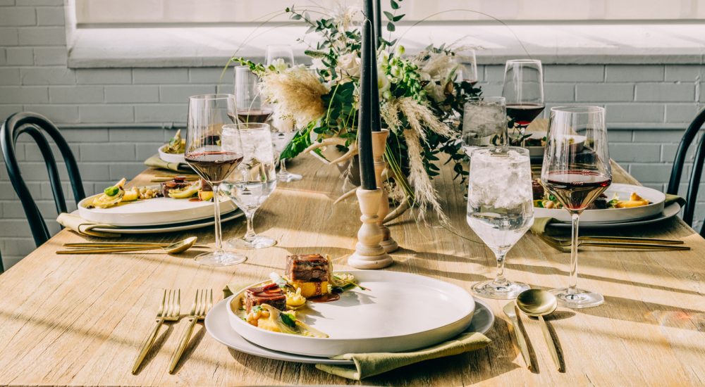 Seated dining table set up with candles and floral arrangements