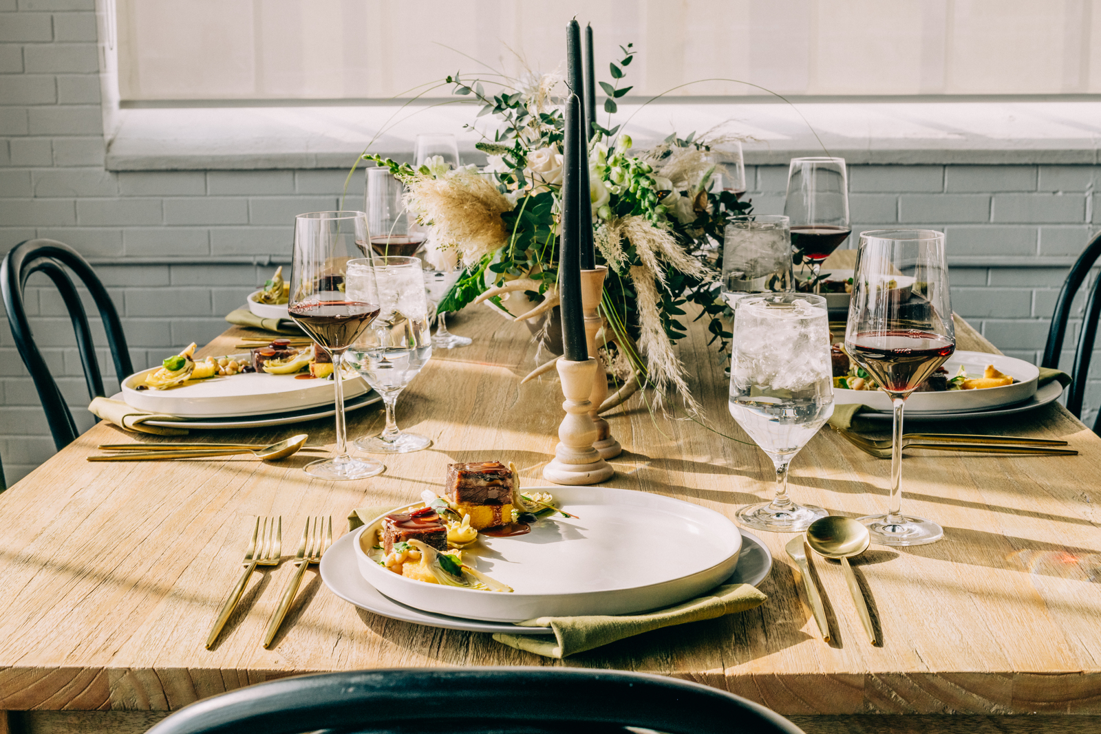 Seated dining table set up with candles and floral arrangements