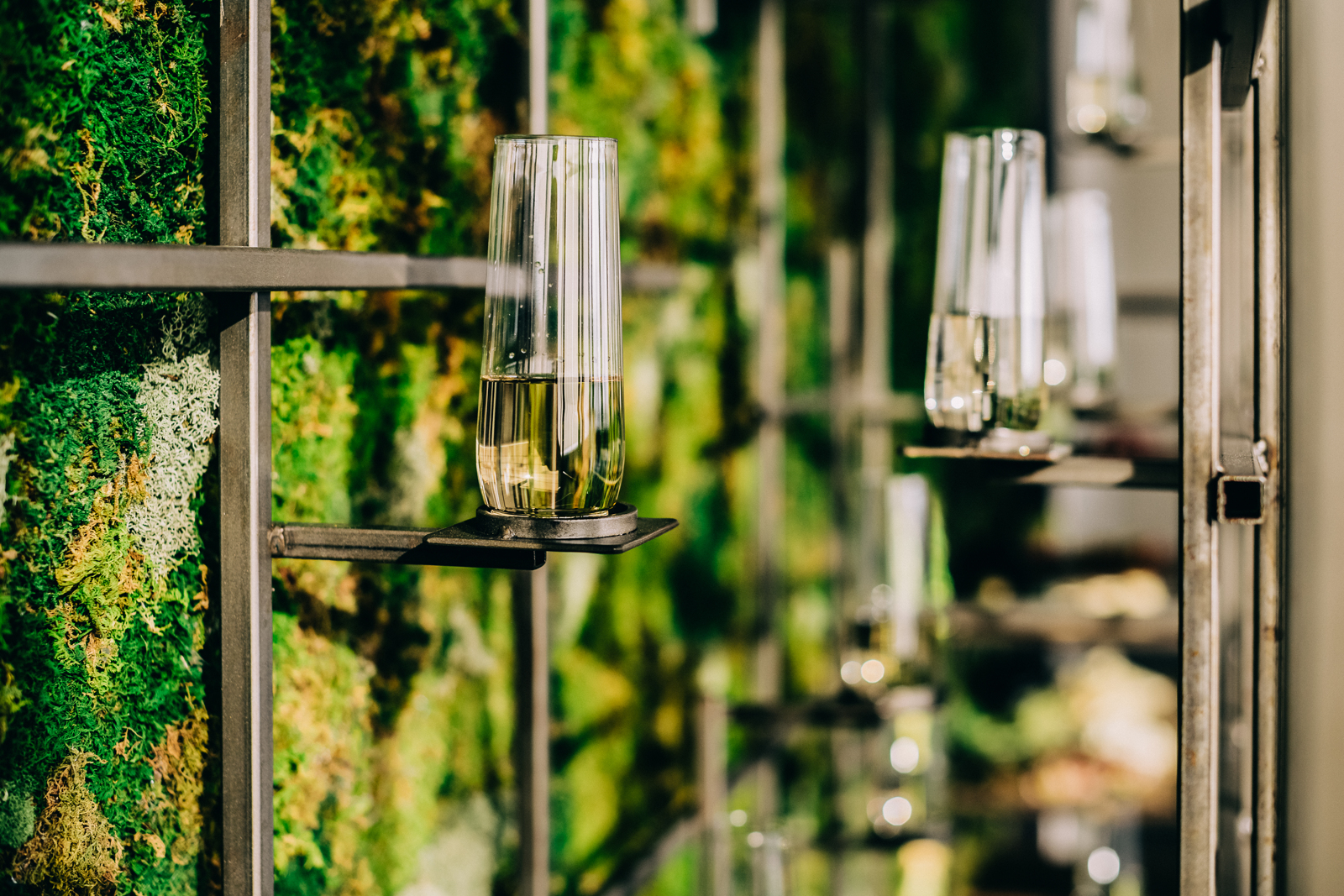 stemless flutes of champagne in holders on wall