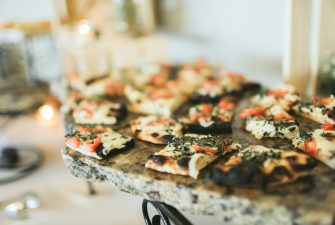 Array of various flatbreads on granite buffet display with fresh tomato and herbs