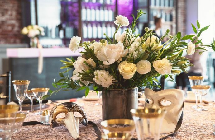 decorated even table with flowers and masks