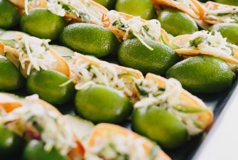 Tray of small tacos served inside of sliced limes