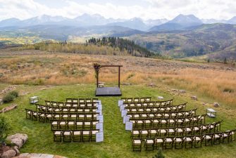 Rows of chairs set up for a wedding ceremony with a scenic view of the mountains as a backdrop