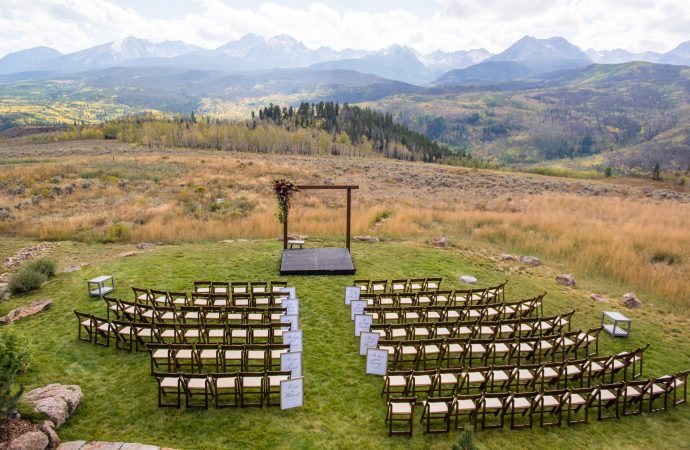 Rows of chairs set up for a wedding ceremony with a scenic view of the mountains as a backdrop