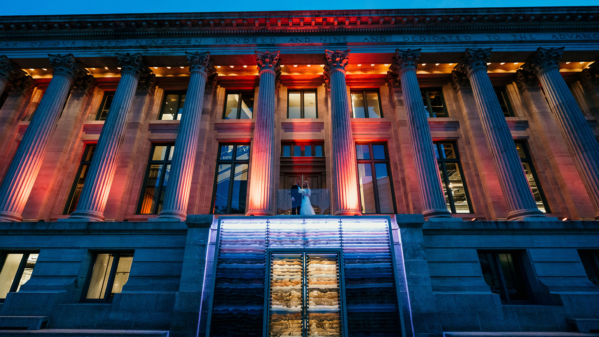 Exterior colaumnade of McNichols Building with red uplighting at night