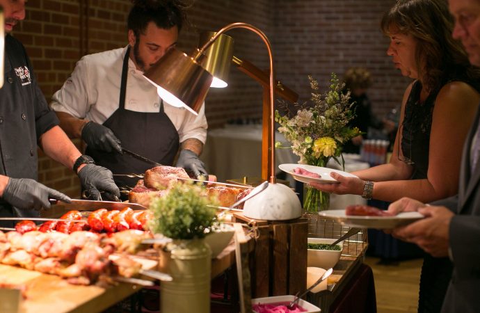 men serving guests plates of food