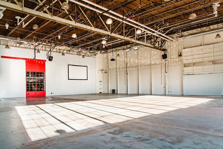 Open industrial style space with metal beams and wooden ceiling