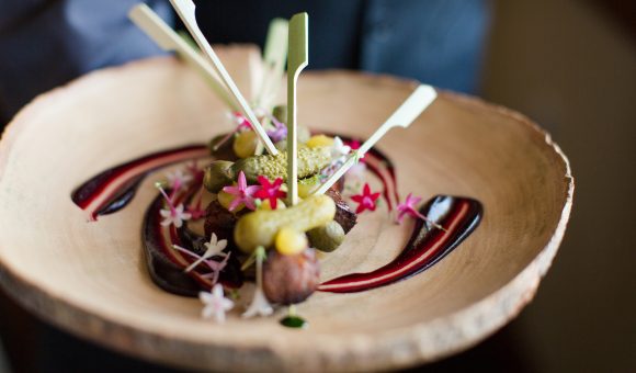 pickles on spears with small flowers & sauce on plate