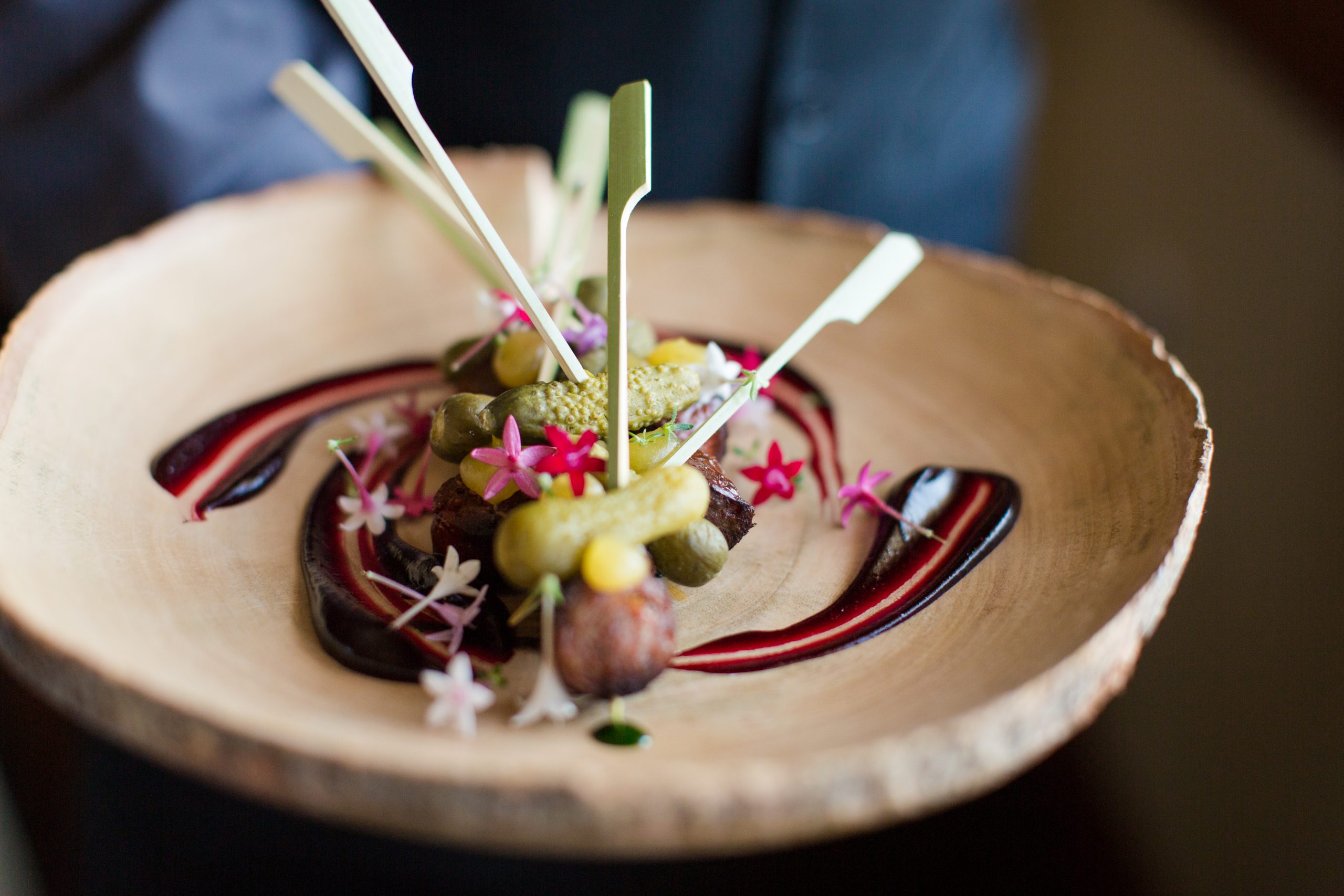 pickles on spears with small flowers & sauce on plate