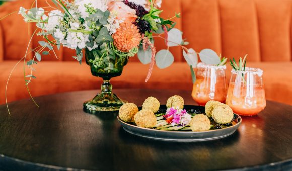 appetizers, drinks and floral arrangement on dark wood table