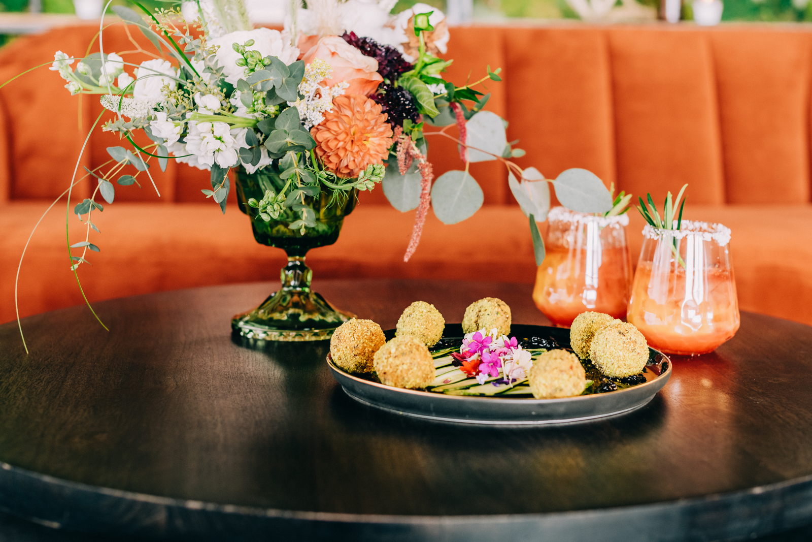 appetizers, drinks and floral arrangement on dark wood table