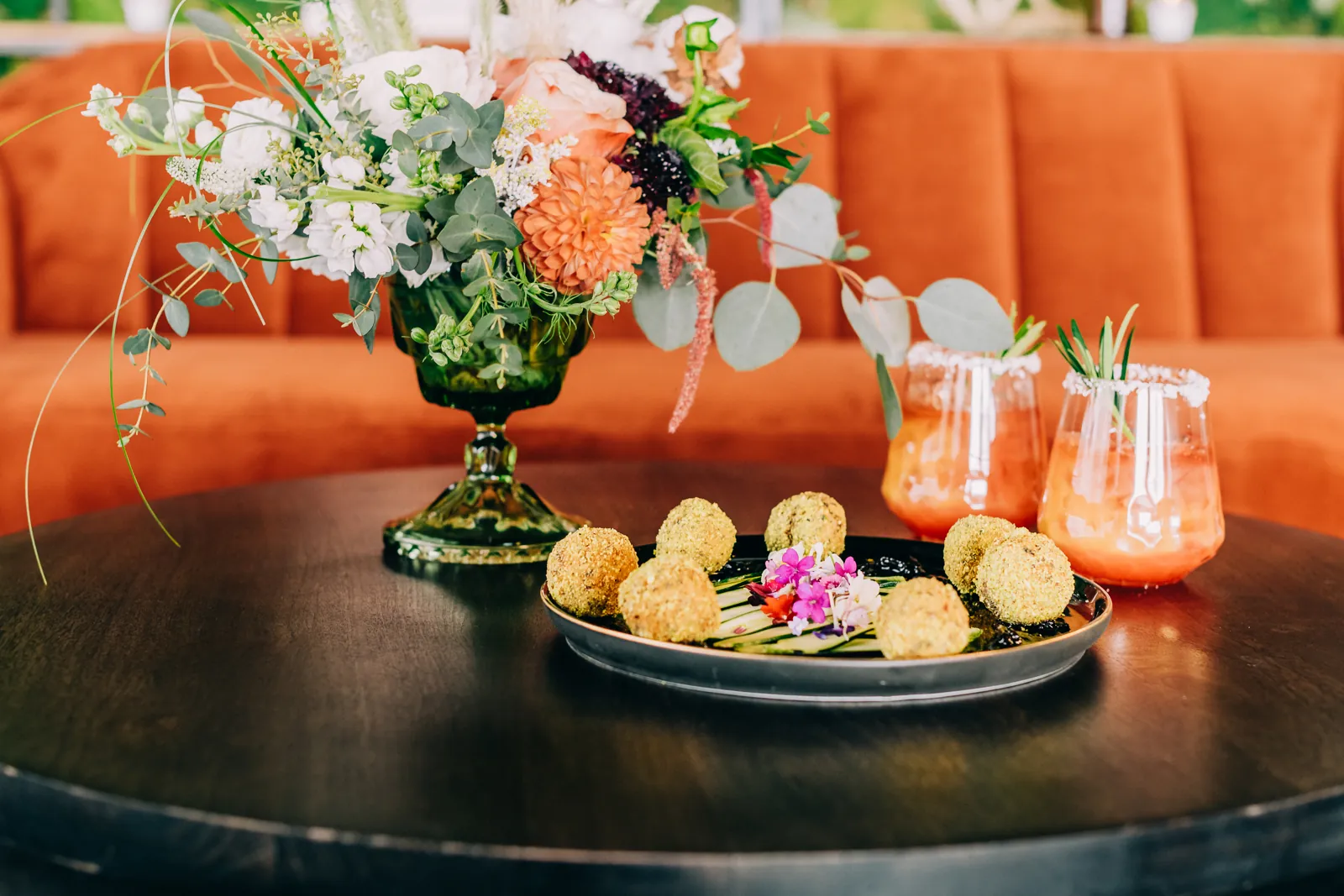 appetizers, drinks and floral arrangement on dark wood table