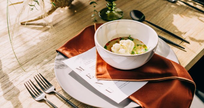 dumpling soup on plate with menu underneath it