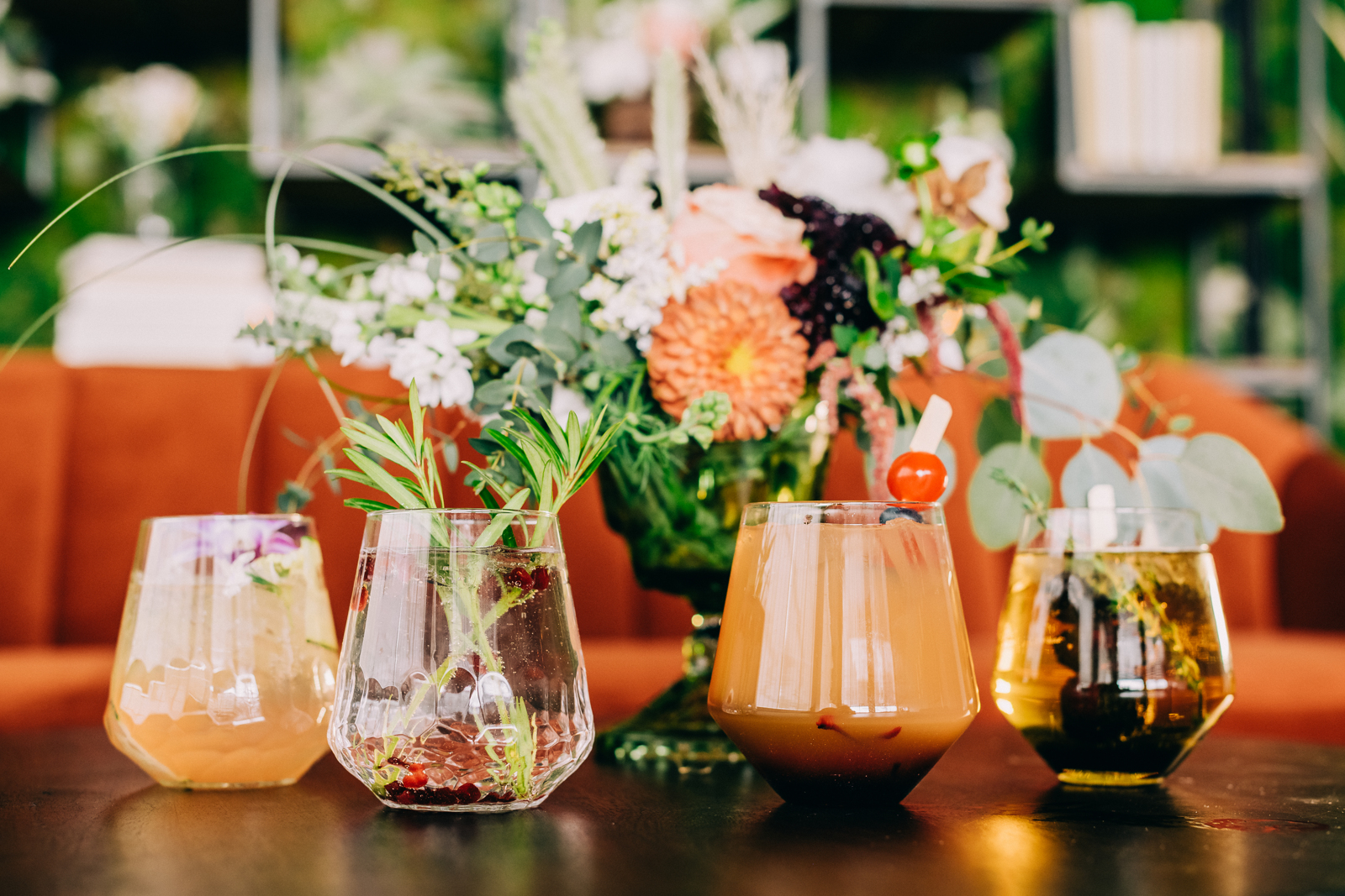 front shot of decorated cocktails in front of floral arrangement