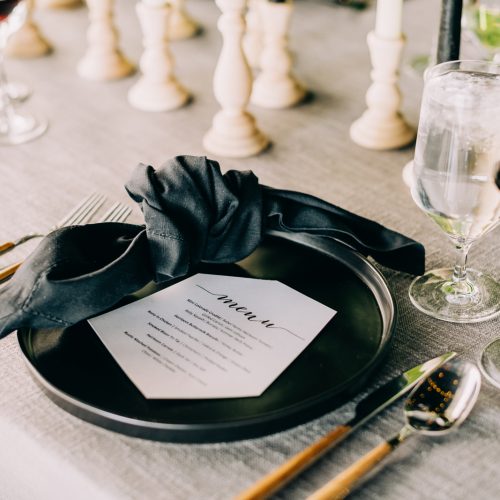 dark place setting, and napkin with menu on plate