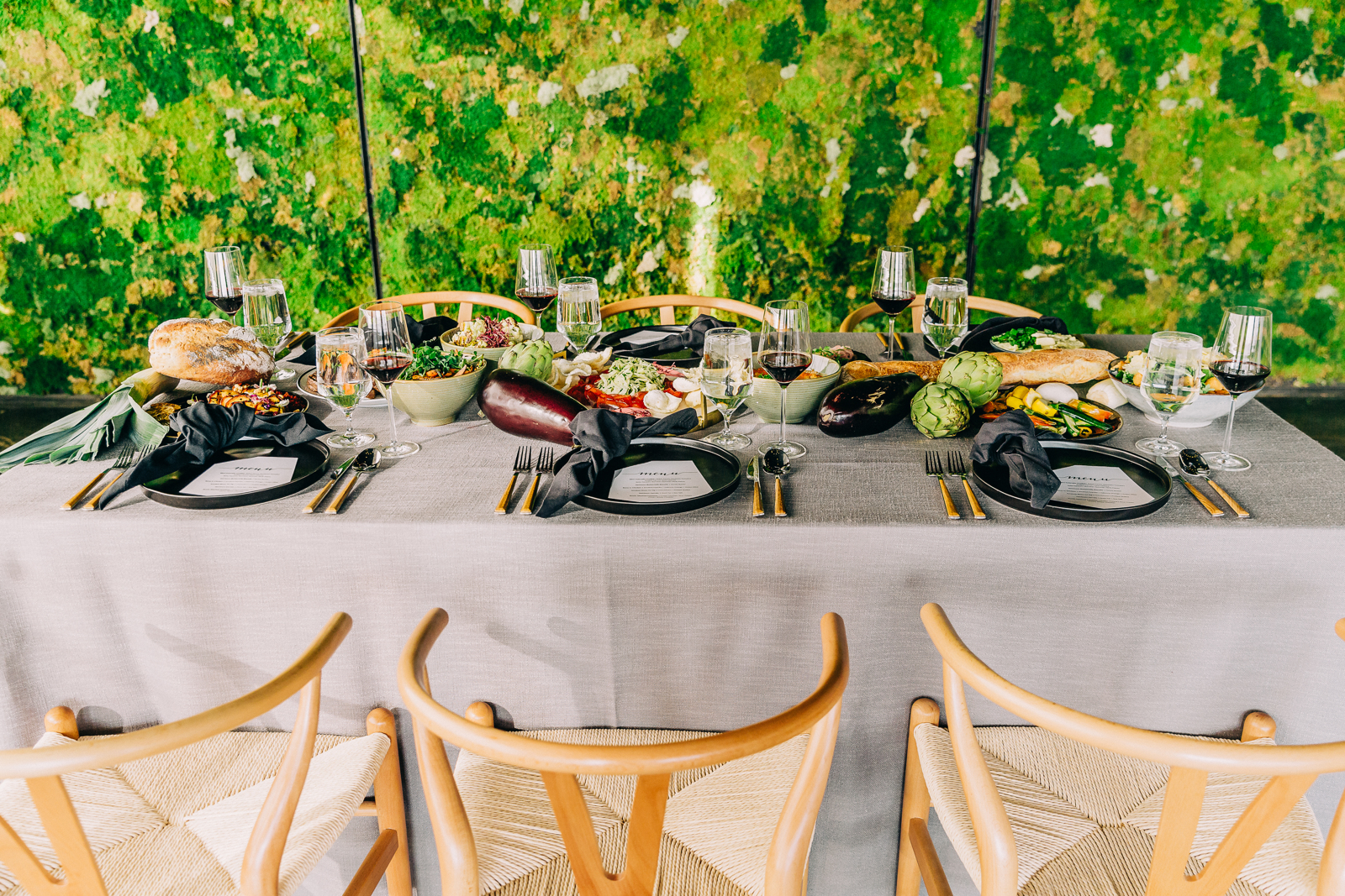 family style table spread with greenery backdrop